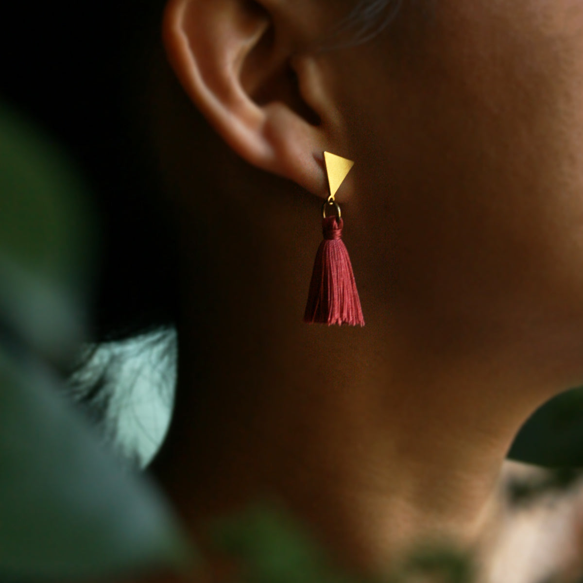 The Vibrant Berlin Stud Earrings _ Triangle stud with merlot red silk Tassel earrings on ears